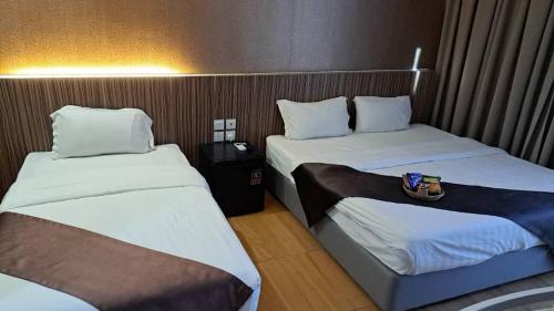 a hotel room with two beds in a room at Ezzyhome Taman Molek in Johor Bahru