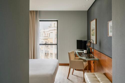 桑坦德Dorma Coliseum的一间卧室，配有一张床和一张带电脑的书桌