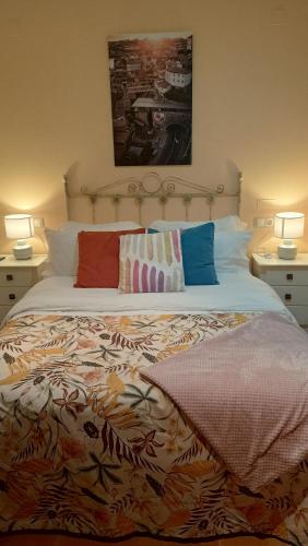 a bedroom with a large bed with two lamps at EDIFICIO CINE MON in Burela de Cabo
