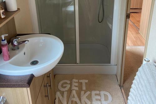 a small bathroom with a sink and a shower at 2 Bed Caravan-Sleeps 6-Pet Friendly in Warton