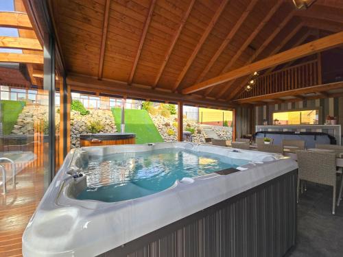 a jacuzzi tub in the middle of a house at Nad Zalew dom z basenem letnim, jacuzzi i sauną, jezioro i trasa Velo Czorsztyn w pobliżu in Sromowce Wyżne