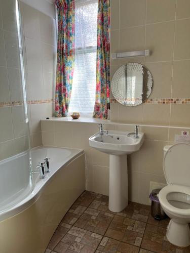 a bathroom with a tub sink and a toilet at The Maid's House in Lanark