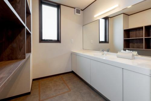 a bathroom with a sink and a mirror at 遊学の宿いさみや 