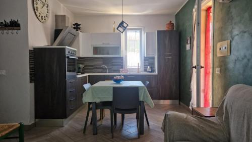 una pequeña cocina con mesa, mesa y sillas en a due passi dal mare, en Campofelice di Roccella