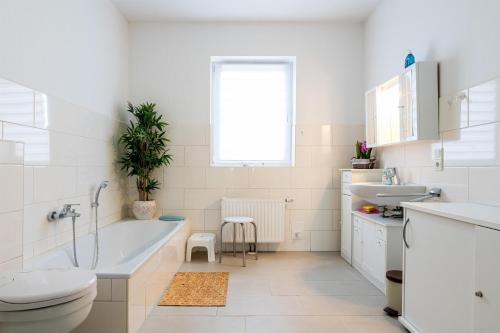 a bathroom with a tub and a toilet and a sink at Ferienwohnungen Meerzeit in Burhave