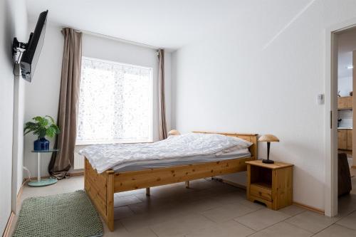 a bedroom with a bed and a window at Ferienwohnungen Meerzeit in Burhave