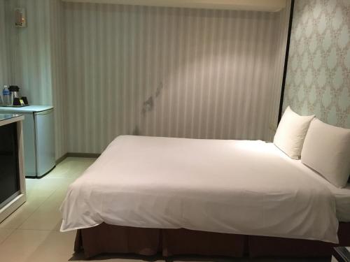a large white bed in a room with a television at Daylight Hotel in Zhonghe