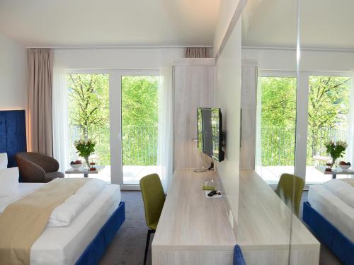 ein Hotelzimmer mit 2 Betten und einem Tisch mit einem TV in der Unterkunft DORMERO SeHo Graz in Graz