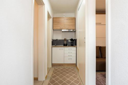 een hal die leidt naar een keuken met witte kasten bij Ferienwohnungen Meerzeit in Burhave