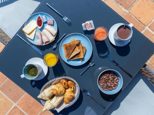 een blauwe tafel met ontbijtproducten erop bij Chateau Maravenne in La Londe-les-Maures
