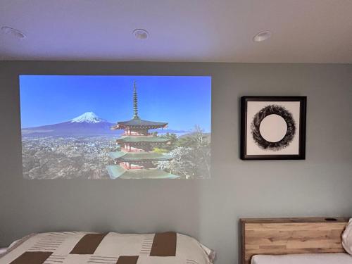 a bedroom with a picture of a building on the wall at 77kawaramachi 新築 in Takamatsu