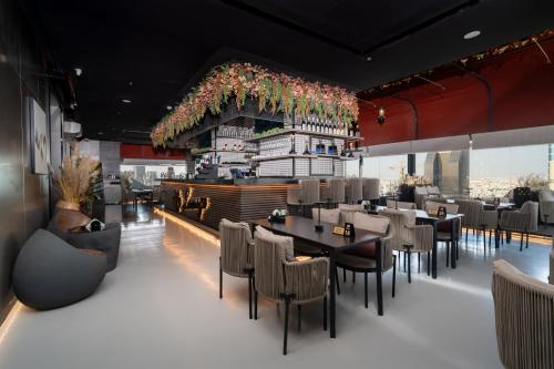 um restaurante com mesas, cadeiras e um bar em Msharef Almoden hotel em Riade