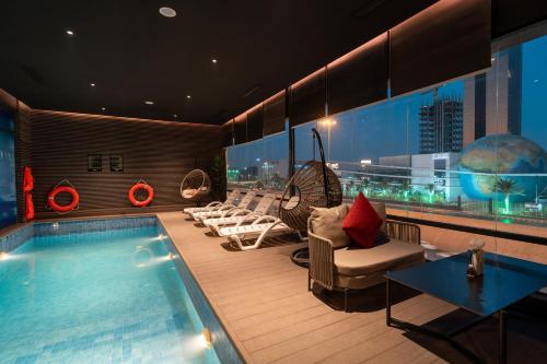 una habitación de hotel con piscina y sillas en Msharef Almoden hotel, en Riad
