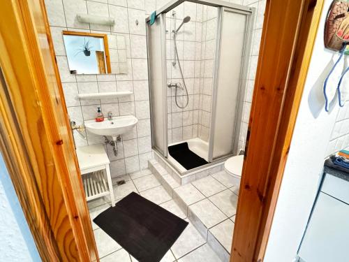 ein Badezimmer mit Dusche und Waschbecken in der Unterkunft Lüttje Paradies in Ruhwarden