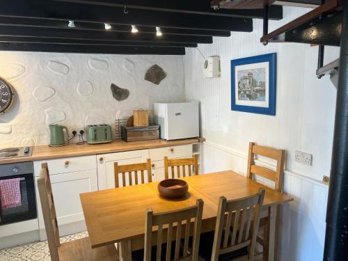 a kitchen with a wooden table and a table and chairs at Cottage in village of Mevagissey Cornwall Sleeps 4 in Mevagissey