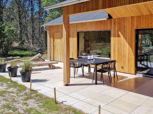 a house with a table and chairs on a patio at 8 person holiday home in Ålbæk in Ålbæk