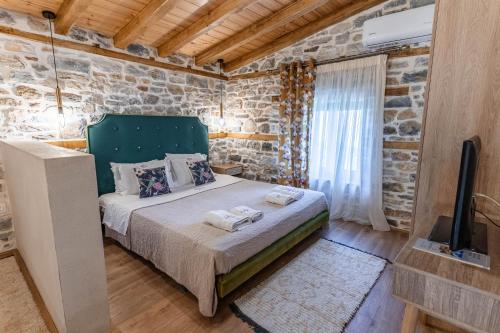 a bedroom with a bed in a stone wall at Guesthouse Iris in Tsagarada