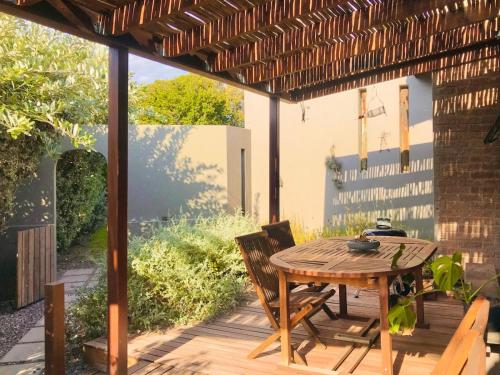 an outdoor patio with a wooden table and chairs at Point Garden Cottage in Elands Bay