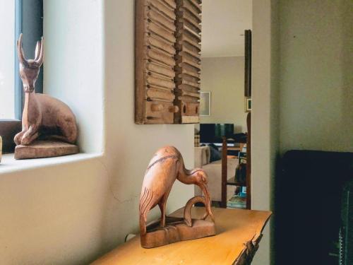 a wooden bird statue sitting on a table in a room at Point Garden Cottage in Elands Bay
