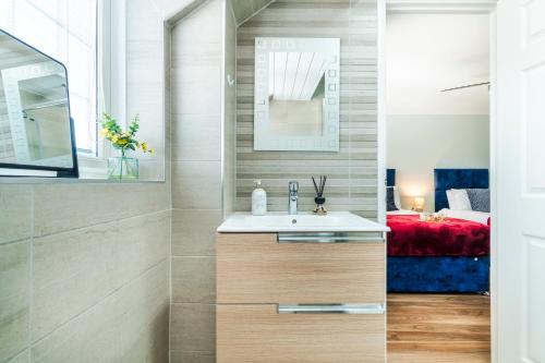 a bathroom with a sink and a bedroom at Halsey 4-Bed Premier Contractor Relocator Family Freeparking in Hemel Hempstead