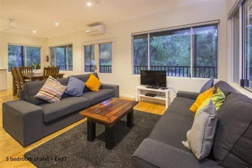a living room with a couch and a coffee table at Sea Breeze East Chalet Yallingup in Yallingup