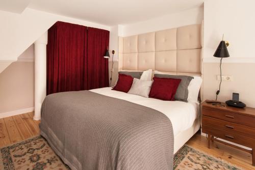 a bedroom with a large bed and a red curtain at CASA AMORA Studio Apartments in Lisbon