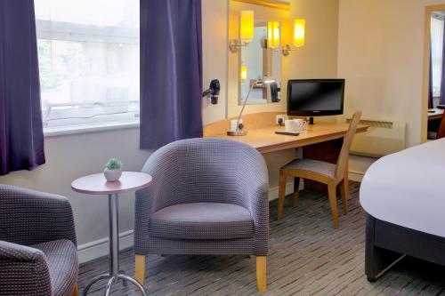 a hotel room with a desk and chairs and a bed at Embassy Hotel, Newcastle City Centre, Sure Collection by Best Western in Newcastle upon Tyne