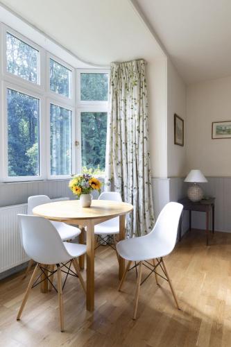 a dining room with a table and white chairs at Monteviot Stables West in Jedburgh