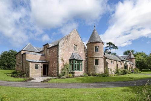 an old stone house with a turret at Monteviot Stables West in Jedburgh
