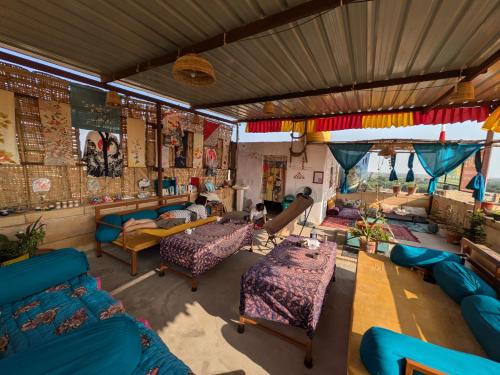a living room with blue couches and tables at Ok-An Homestay in Jaisalmer