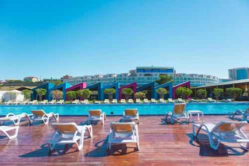 a group of chairs sitting next to a swimming pool at AF HOTEL AQUAPARK in Novxanı