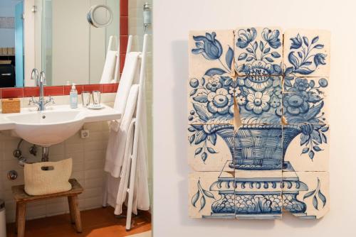 a bathroom with a blue and white vase on the wall at CASA AMORA Studio Apartments in Lisbon