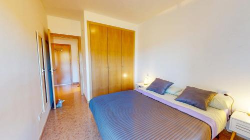 a bedroom with a bed with blue pillows on it at Apartamento en Alcala de la Selva by Family Homes in Alcalá de la Selva