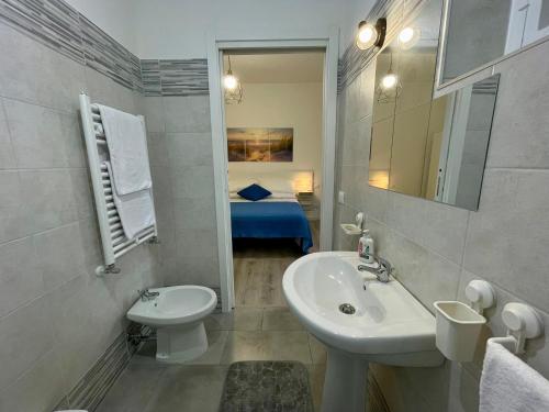 a white bathroom with a sink and a toilet at Relax Apartment in Civitavecchia