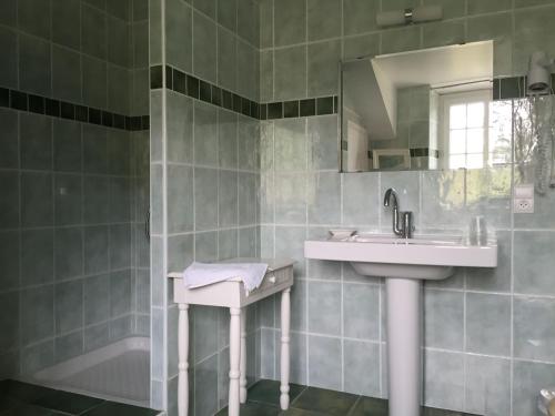une salle de bains avec lavabo, miroir et baignoire dans l'établissement Gîte de Ségonac, à Saint-Georges-de-Luzençon