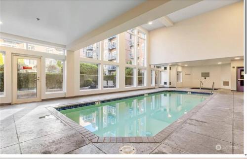 a large swimming pool in a building with windows at Vibrant City Gem/99 Walk/Pike Pl/Pool/Pet/Parking in Seattle