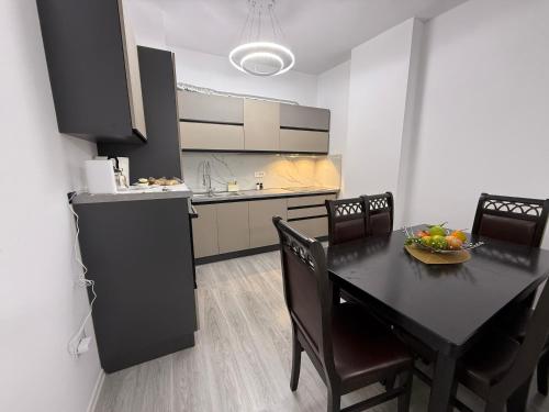 a kitchen and dining room with a black table and chairs at Modern 2BR Near City Ring & Main Road Access in Tirana