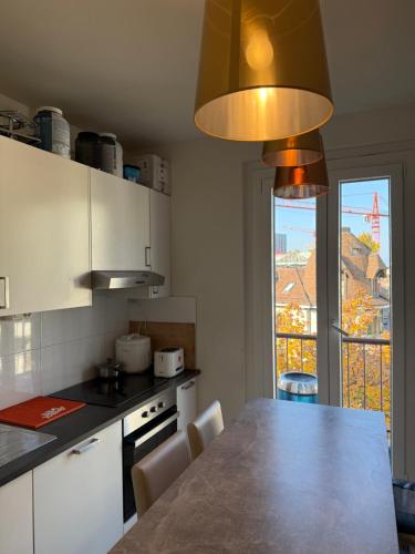 eine Küche mit einem Tisch und einem großen Fenster in der Unterkunft chambre en centre ville in Genf