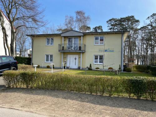 ein großes gelbes Haus mit Balkon darüber in der Unterkunft Villa Waterkant EG in Baabe