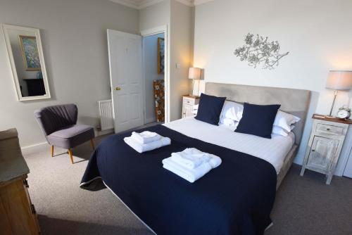 a bedroom with a large bed with towels on it at Arthouse Canterbury-Free Secure Parking in Canterbury