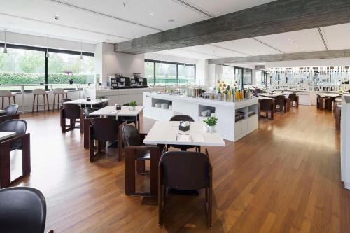 a restaurant with tables and chairs and a bar at NH Milano Congress Centre in Assago