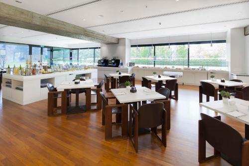 a restaurant with tables and chairs in a room at NH Milano Congress Centre in Assago