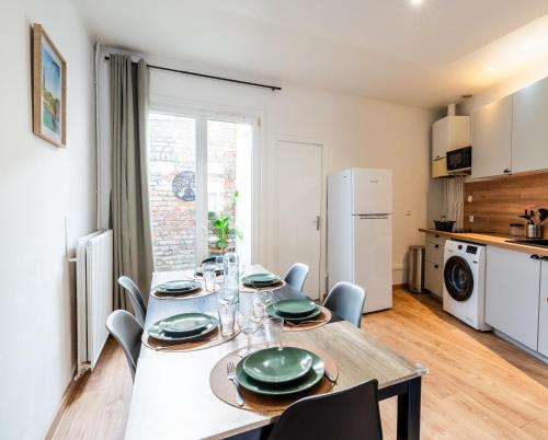 a dining room with a table and chairs and a kitchen at LE 219 - Maison tout confort à Amiens Wi-Fi rapide, Netflix, calme & proche centre in Amiens