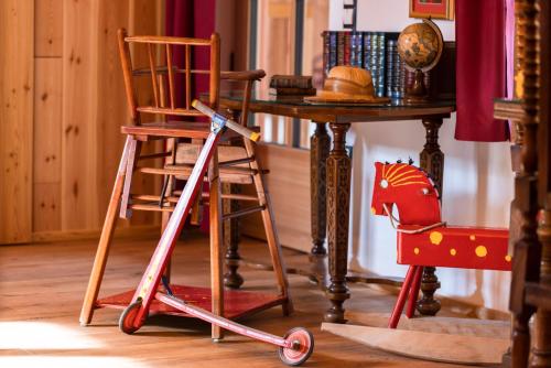 a wooden ladder next to a table and a wooden chair at Wohnung FRIEDRICH in Soprabolzano