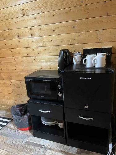 a kitchen with a microwave and a coffee maker at Pine Marten Bar Glenmore Pods in Aviemore