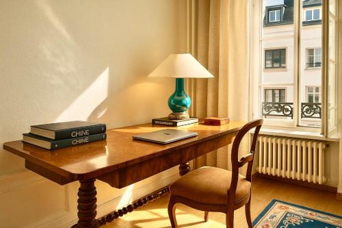 een bureau met een laptop, een lamp en een stoel bij La Belle Époque Apartment in Luxemburg