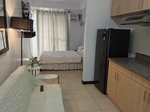 a small kitchen with a bed and a refrigerator at The Redwoods SM Fairview with Balcony in Manila