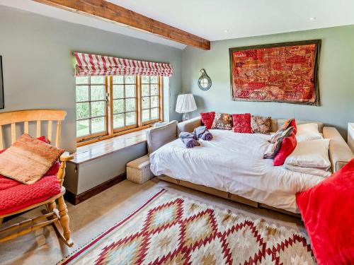 a bedroom with a bed and a couch and windows at 4 Bed in Icklesham BT067 in Icklesham