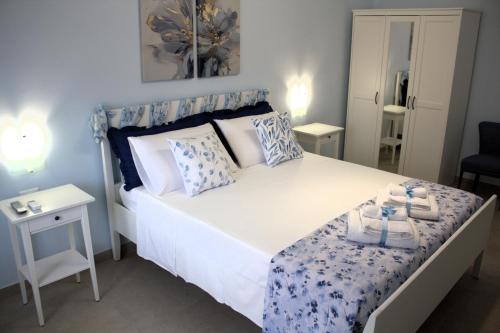 a bedroom with a bed with blue and white pillows at a casa rà Palumma Rooms in Avola