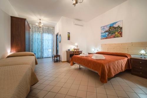 una camera d'albergo con due letti e un tavolo di IL VIVAIO Bed and Breakfast a Santa Teresa di Riva